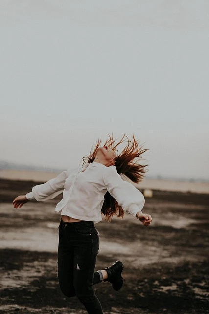 Une femme en mouvement, les bras ouverts, symbolise la liberté d’être soi, la reconnexion au corps et l’élan de transformation en Gestalt-thérapie.