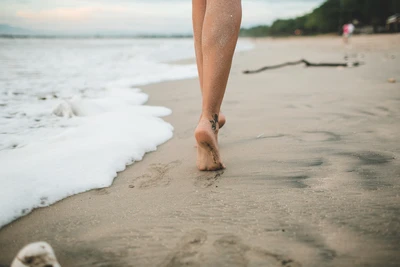 Une personne marche pieds nus sur la plage, chaque pas symbolisant la responsabilité, le choix conscient et le cheminement personnel en Gestalt-thérapie