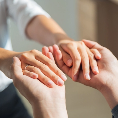 Deux personnes se tiennent les mains avec douceur, symbole de rencontre, de confiance et d'accompagnement bienveillant en Gestalt-thérapie.
